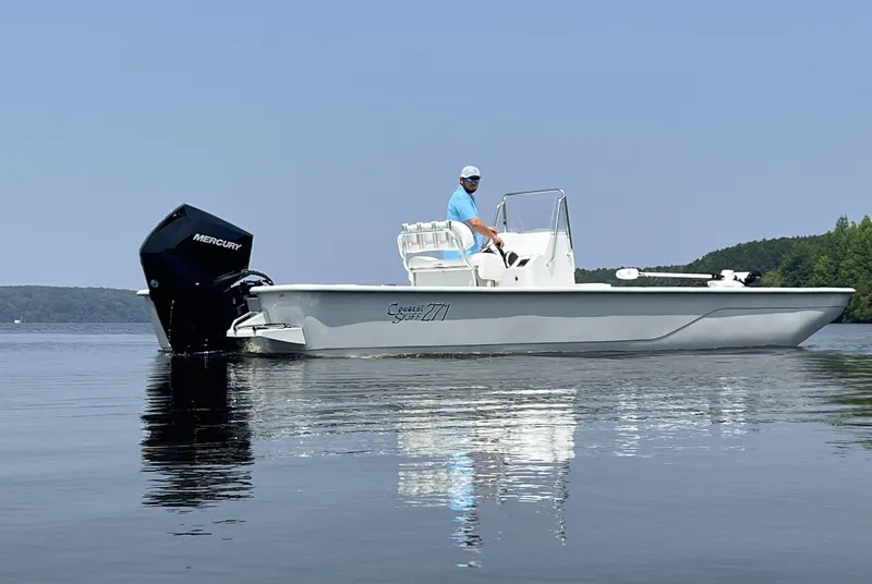 Slide: The Image of 2024 Coastal Skiff 271 boat on calm water with Mercury outboard motor. - 24