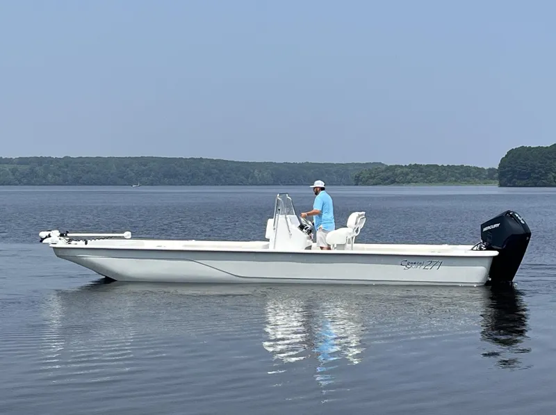 Slide: The Image of 2024 Coastal Skiff 271 boat on calm lake with driver. - 30