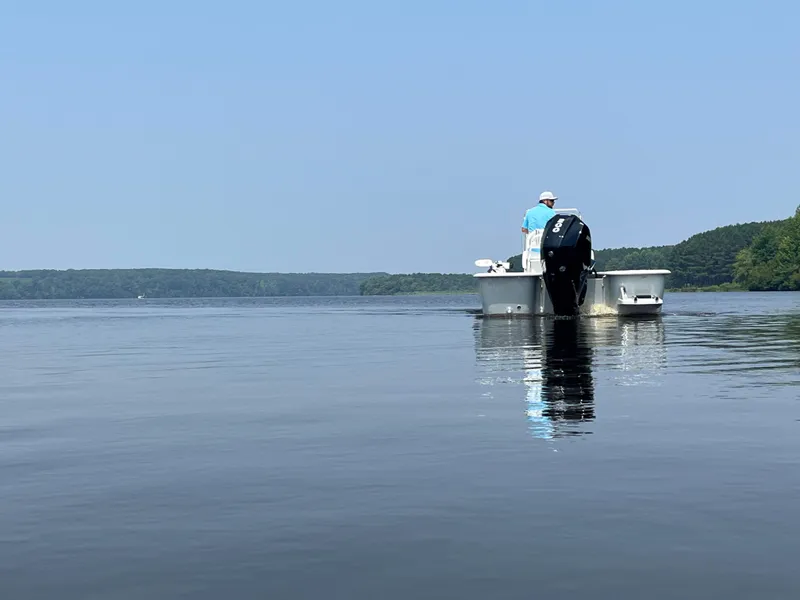 Slide: The Image of 2024 Coastal Skiff 271 on calm lake waters with a person onboard. - 34
