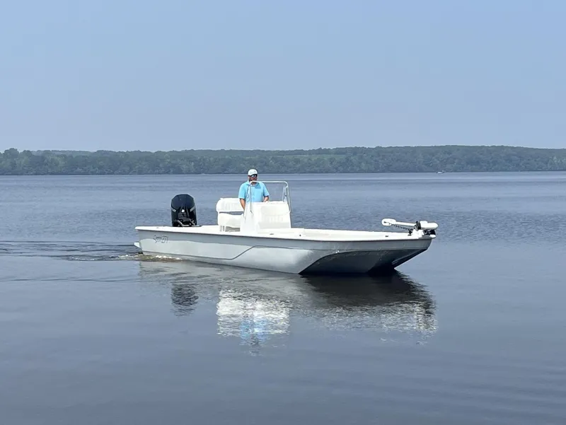 Slide: The Image of 2024 Coastal Skiff 271 boat cruising on a calm lake. - 9