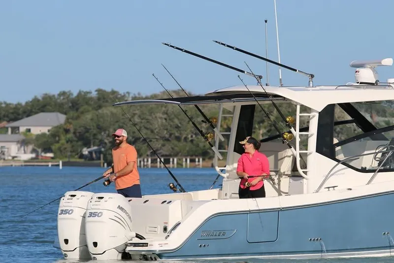 Slide: The Image of 2024 Boston Whaler 325 Conquest boat with two people fishing on deck. - 2