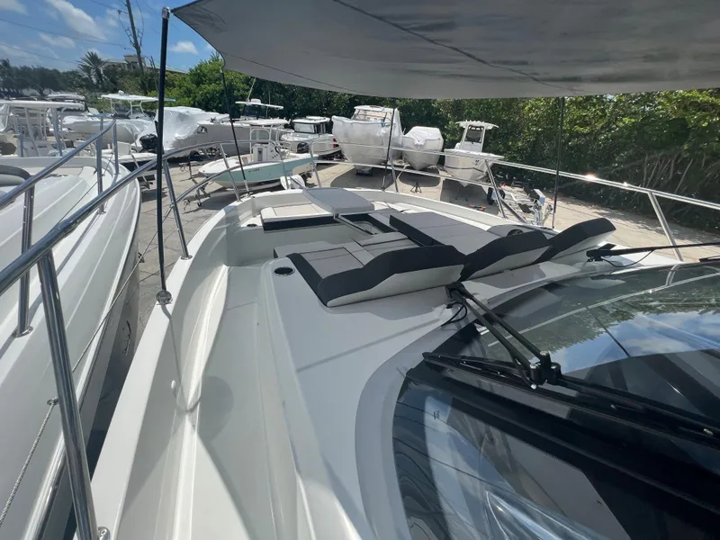 Slide: The Image of 2024 Jeanneau Leader 12.5 boat with sun loungers and canopy, docked at marina. - 10