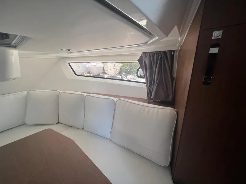 Slide: The Image of Interior cabin of 2024 Jeanneau Leader 12.5 with white cushions and wooden accents. - 16