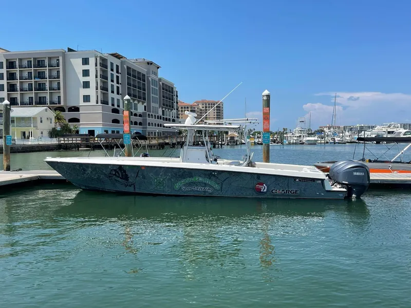 Slide: The Image of 2000 Contender 36 Open boat docked at a marina with waterfront buildings. - 0