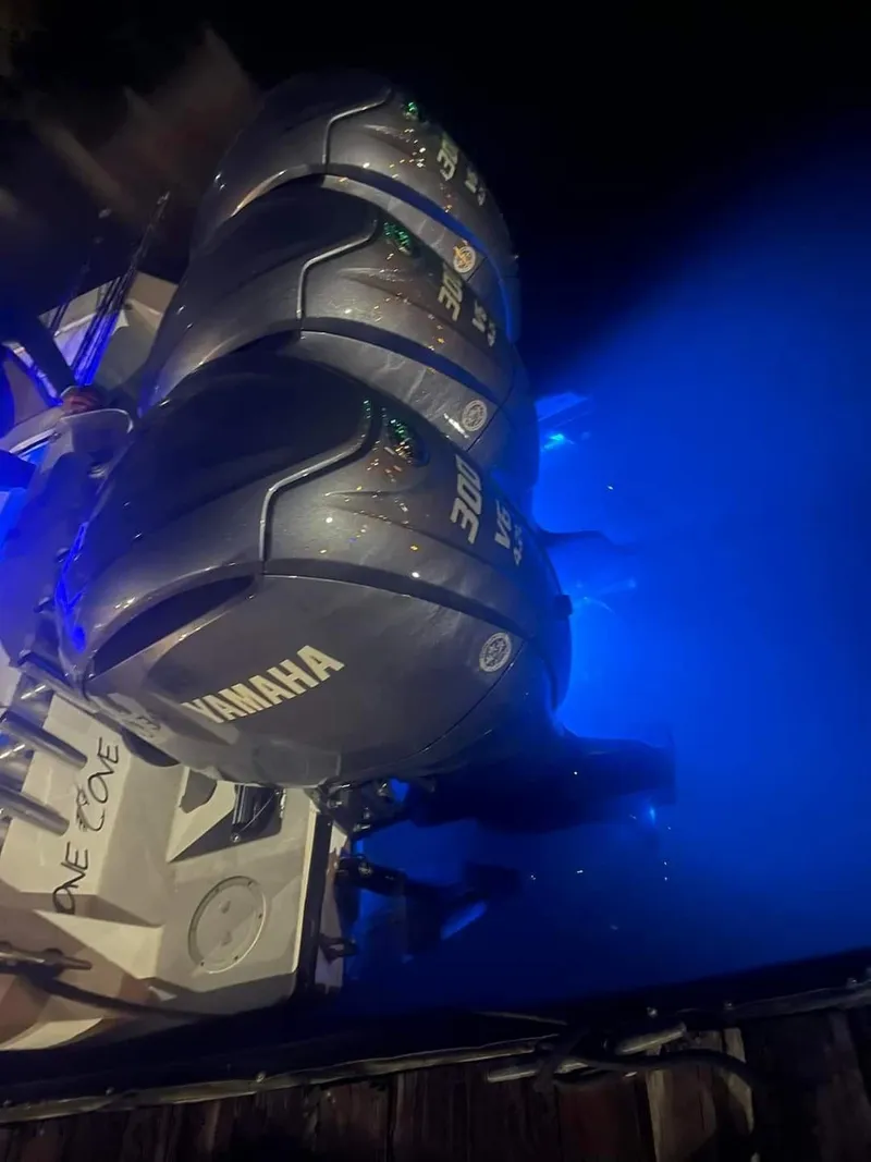 Slide: The Image of Triple Yamaha outboard engines on a 2000 Contender 36 Open boat illuminated at night. - 2