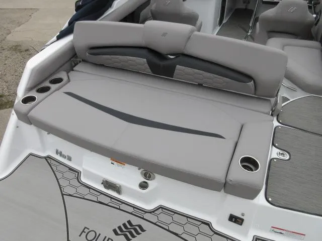 Slide: The Image of 2024 Four Winns HD3 boat with spacious rear seating and cup holders. - 17