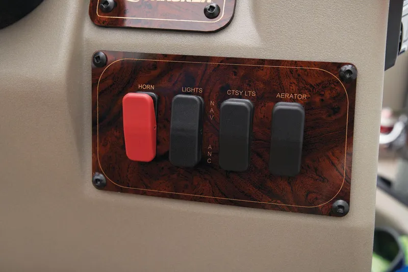 Slide: The Image of Control panel of 2024 Sun Tracker Bass Buggy 18 DLX with switches for horn, lights, and aerator. - 39