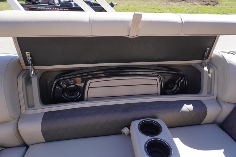 Slide: The Image of 2024 Sun Tracker Fishin' Barge 20 DLX storage compartment with cup holders and sleek design. - 10
