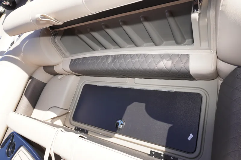 Slide: The Image of 2024 Sun Tracker Fishin' Barge 20 DLX interior storage compartment with cushioned seating. - 13