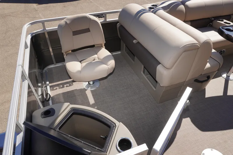 Slide: The Image of 2024 Sun Tracker Fishin' Barge 20 DLX interior with beige seating and storage compartments. - 18