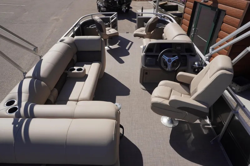 Slide: The Image of 2024 Sun Tracker Fishin' Barge 20 DLX interior with beige seating and steering console. - 6