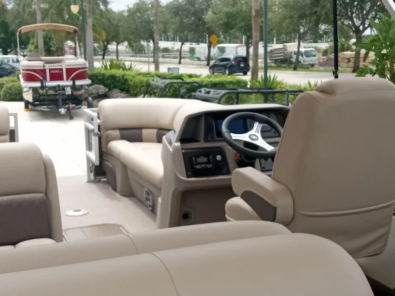 Slide: The Image of 2024 Sun Tracker SportFish 22 XP3 interior with beige seating and steering console. - 4