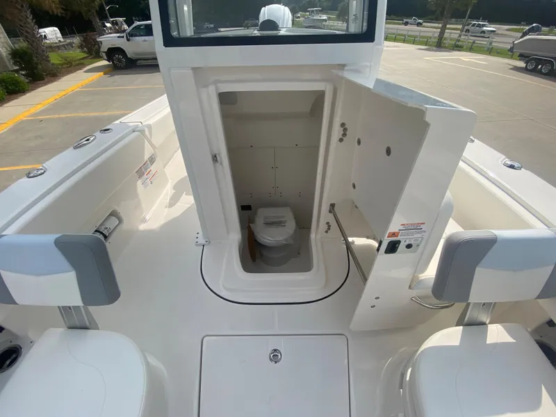 Slide: The Image of 2024 Robalo 266 Cayman boat with open console storage and toilet. - 26