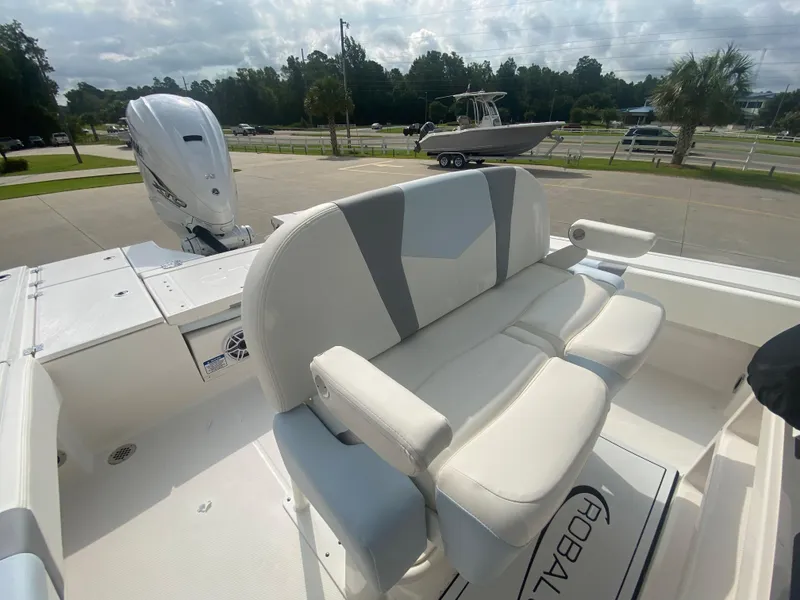 Slide: The Image of 2024 Robalo 266 Cayman boat with cushioned seating and outboard motor. - 11