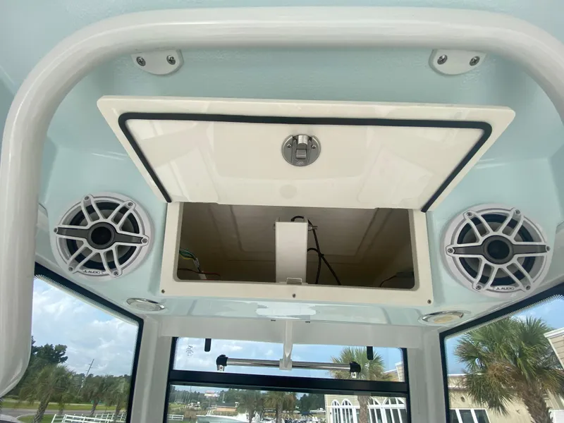 Slide: The Image of 2024 Robalo 266 Cayman boat interior with speakers and storage compartment. - 18