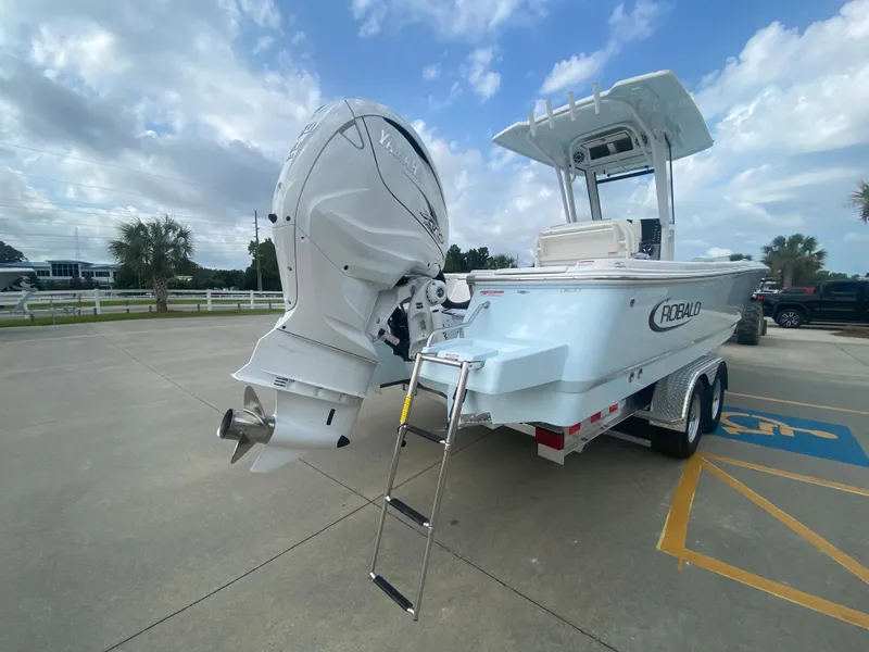 Slide: The Image of 2024 Robalo 266 Cayman boat with outboard motor and trailer in parking lot. - 3