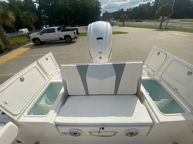 Slide: The Image of 2024 Robalo 266 Cayman boat with open storage compartments and seating area. - 8
