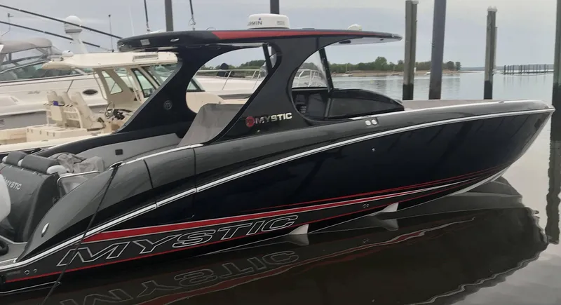 The Image of 2017 Mystic Powerboats M4200 in black, docked at a marina. - 1