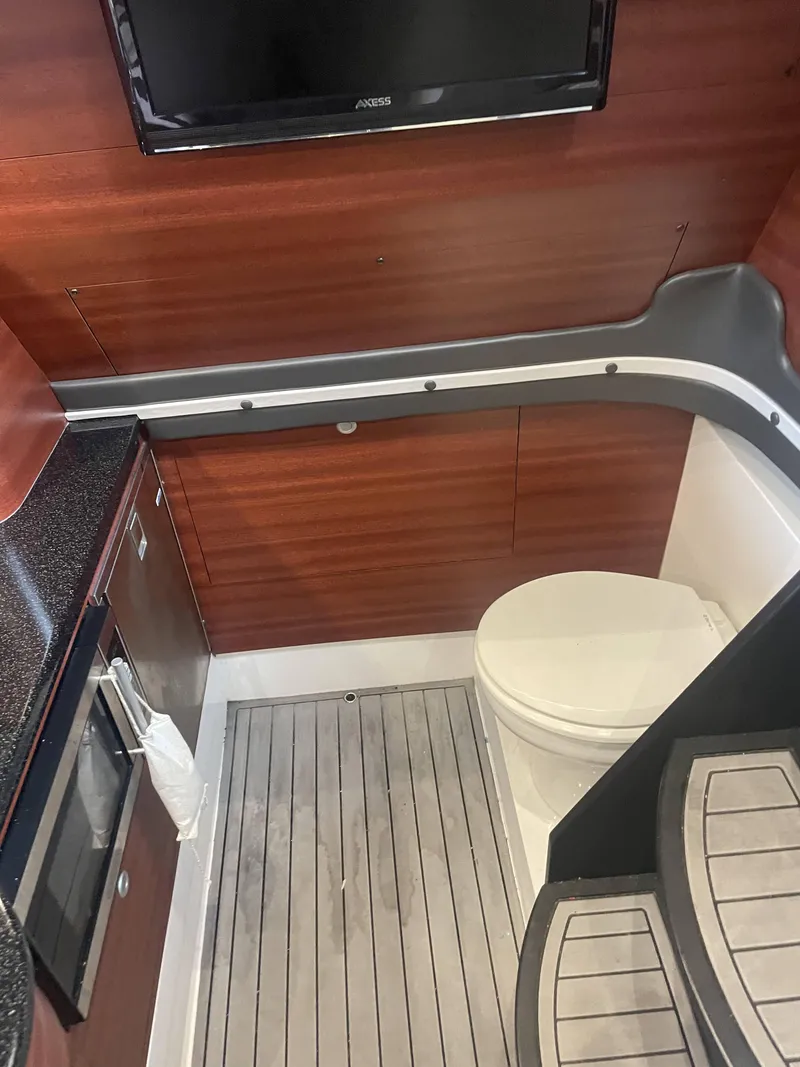 Slide: The Image of 2017 Mystic Powerboats M4200 interior bathroom with wooden paneling and modern amenities. - 15