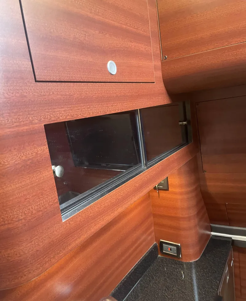 Slide: The Image of 2017 Mystic Powerboats M4200 interior with wood finish and black countertop. - 17