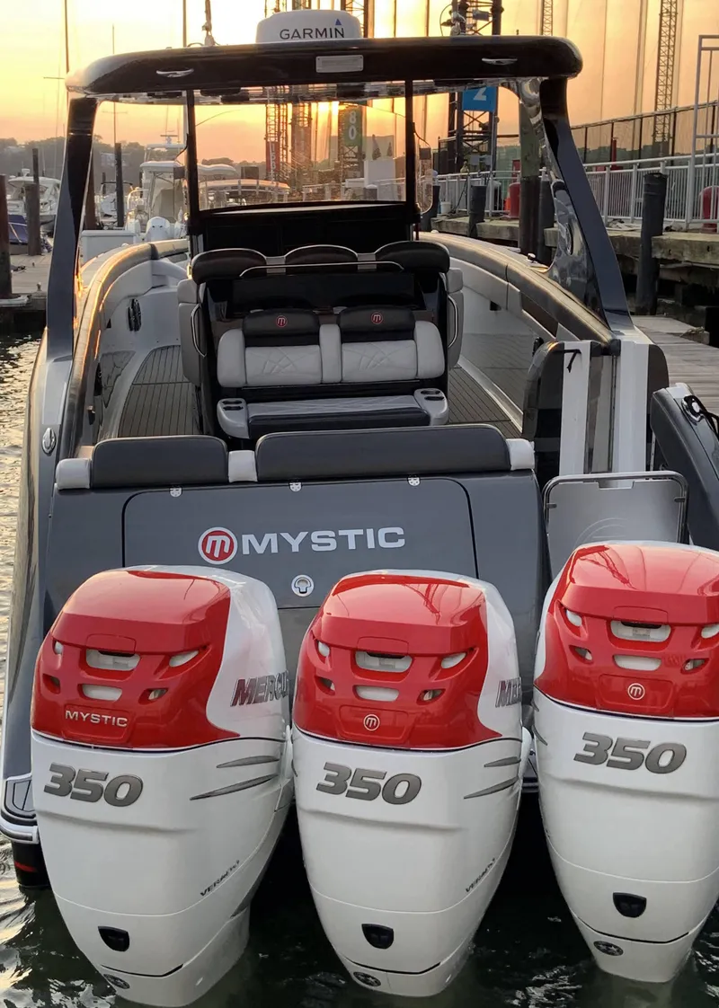 Slide: The Image of 2017 Mystic Powerboats M4200 with triple 350 horsepower engines docked at sunset. - 3