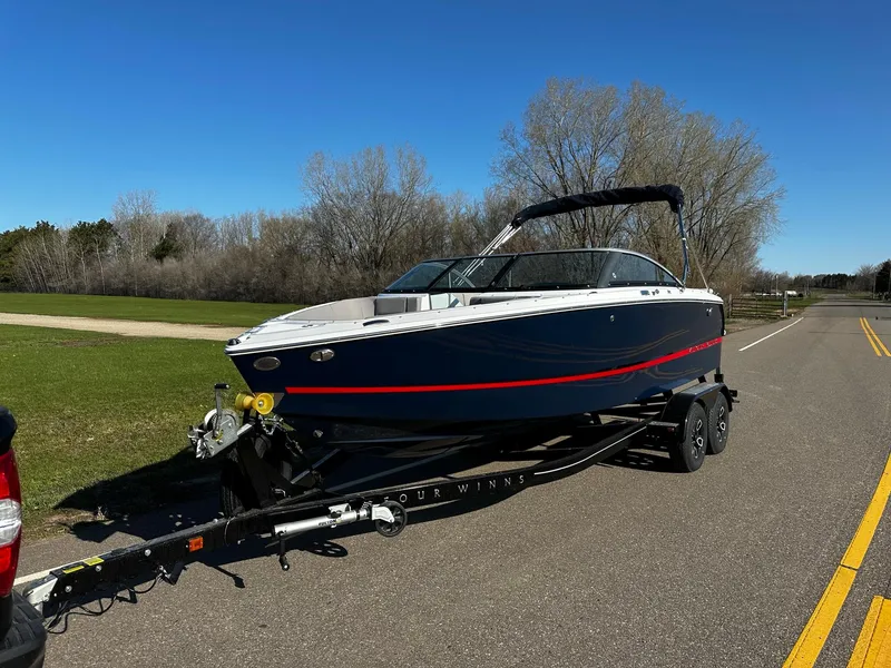 Slide: The Image of 2023 Four Winns H2 boat on a trailer, parked on a road. - 2