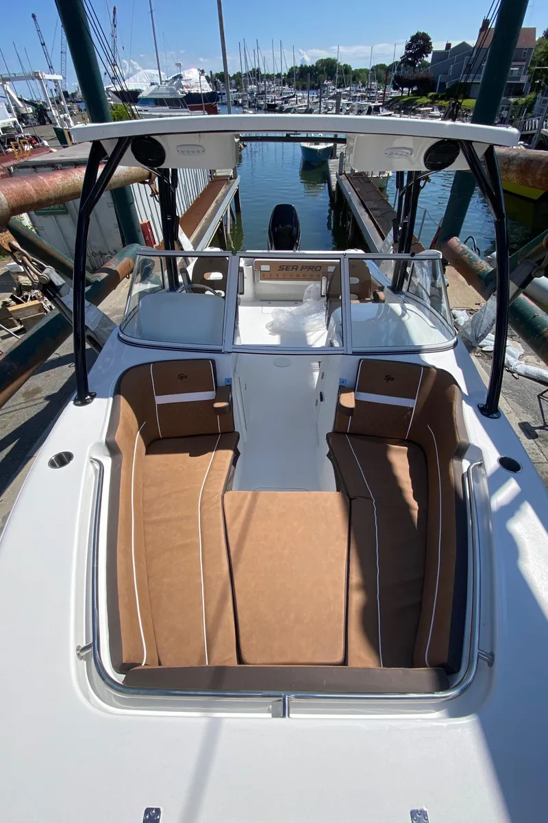 Slide: The Image of 2024 Sea Pro 240 Dual boat docked at a marina, featuring spacious seating. - 19