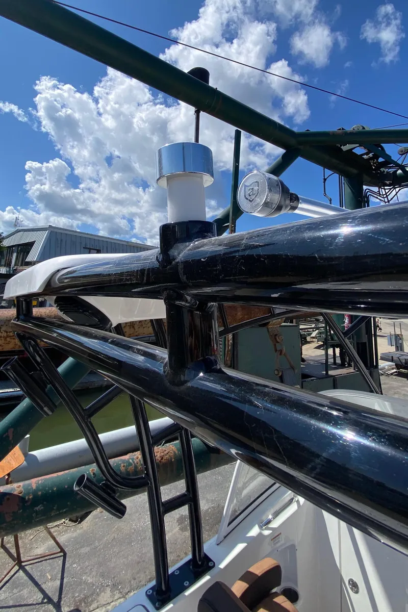 Slide: The Image of 2024 Sea Pro 240 Dual boat with sleek black railings under a bright blue sky. - 20