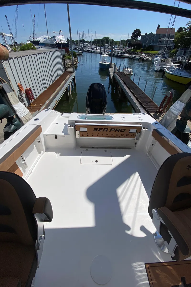 Slide: The Image of 2024 Sea Pro 240 Dual boat docked at a marina, view of the spacious deck. - 7