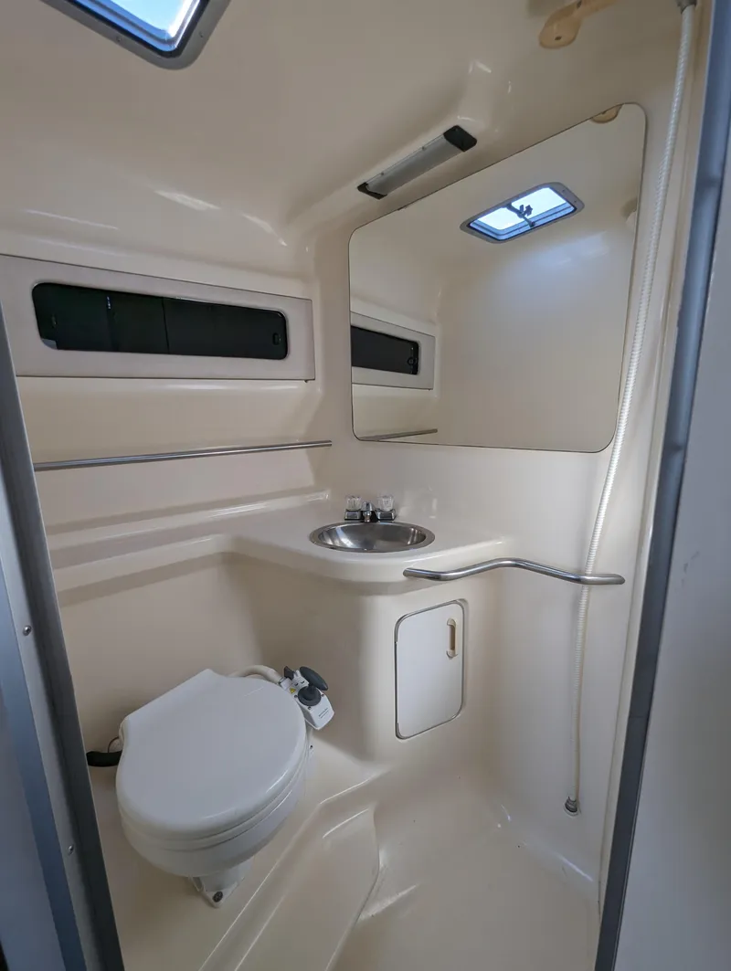 Slide: The Image of 1992 Sea Ray 330 Express Cruiser bathroom with sink, toilet, and mirror. - 11