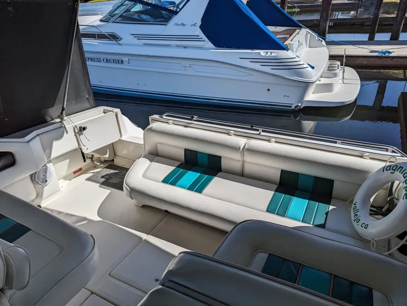 Slide: The Image of 1992 Sea Ray 330 Express Cruiser with white and teal seating, docked at a marina. - 5