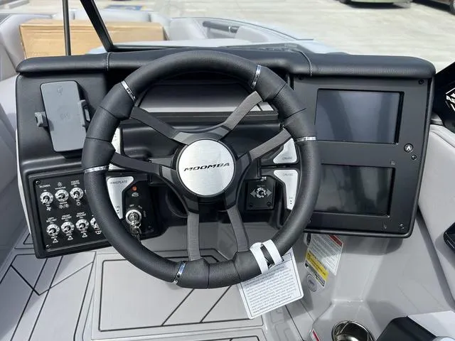 Slide: The Image of 2024 Moomba Craz boat dashboard with steering wheel and control panel. - 14