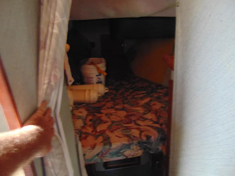 Slide: The Image of 1991 Bayliner 3288 Motoryacht cabin interior with floral bedding and storage items. - 11