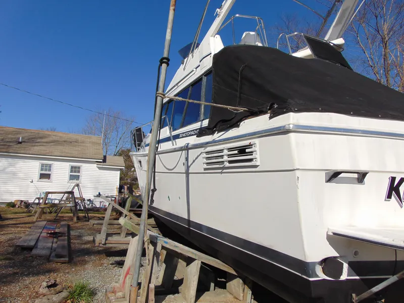 Slide: The Image of 1991 Bayliner 3288 Motoryacht on dry dock, covered, with clear blue sky background. - 26