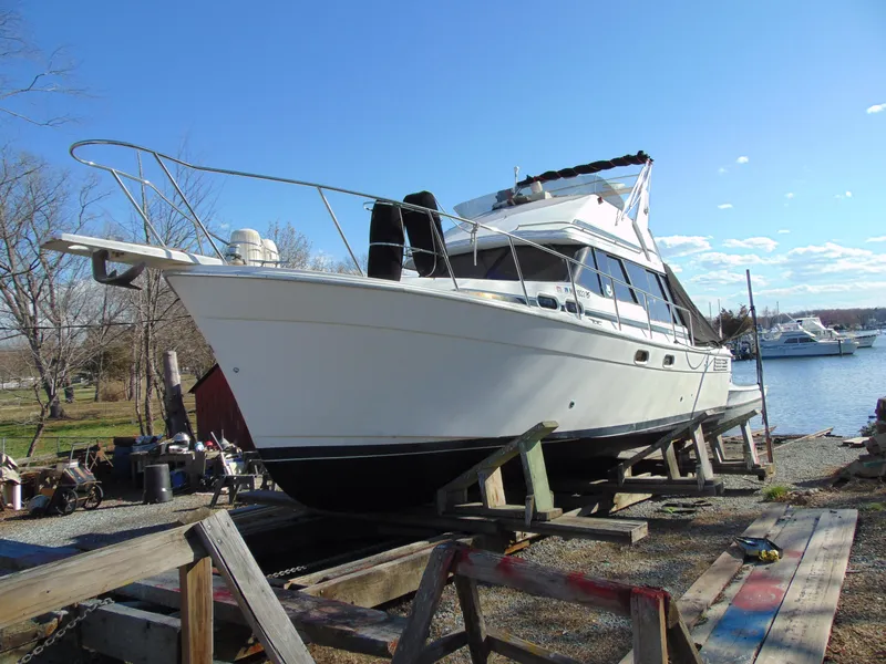 Slide: The Image of Bayliner 3288 Motoryacht 1991 on dry dock near a serene waterfront. - 28