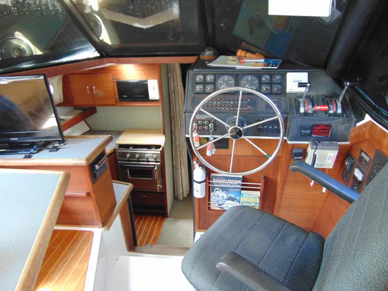Slide: The Image of 1991 Bayliner 3288 Motoryacht interior with helm, kitchen, and seating area. - 9