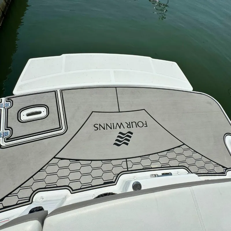Slide: The Image of Interior of 2021 Four Winns HD8 boat, featuring a comfortable white and gray seat. - 11