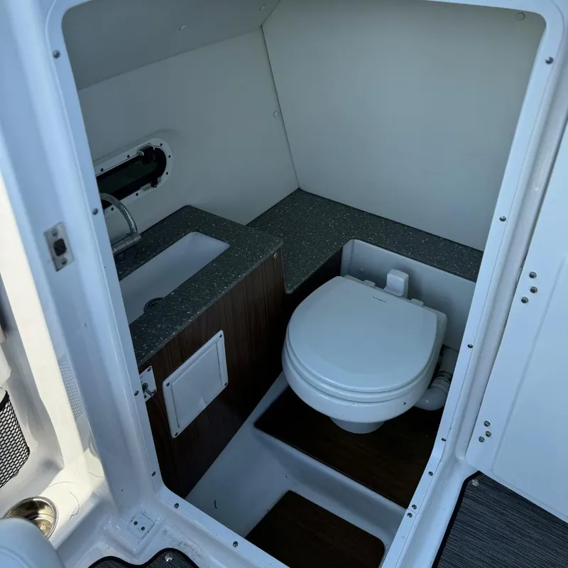 Slide: The Image of 2021 Four Winns HD8 boat cockpit with steering wheel and captain's seat. - 6