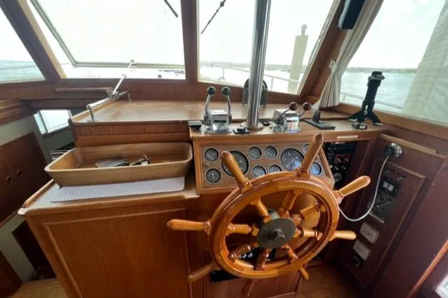 Slide: The Image of 1987 Grand Banks 42 Classic Trawler helm with wooden wheel and navigation instruments. - 12