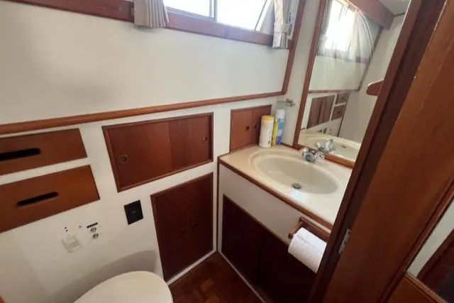 Slide: The Image of 1987 Grand Banks 42 Classic Trawler bathroom with wood accents and sink. - 18