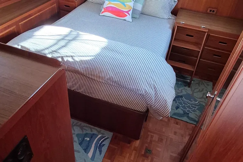 Slide: The Image of Cozy bedroom in 1987 Grand Banks 42 Classic Trawler with striped bedding and wooden cabinetry. - 21
