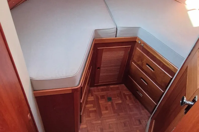 Slide: The Image of 1987 Grand Banks 42 Classic Trawler cabin with wooden drawers and cushioned bed. - 23
