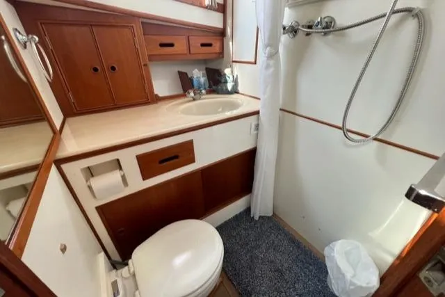 Slide: The Image of 1987 Grand Banks 42 Classic Trawler bathroom with shower, sink, and wooden cabinetry. - 27