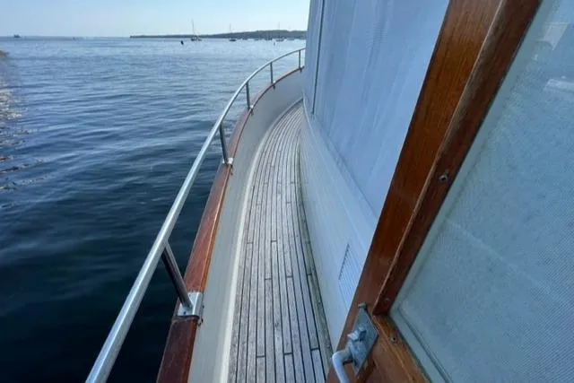Slide: The Image of 1987 Grand Banks 42 Classic Trawler deck view, showcasing wooden railings and serene waters. - 29
