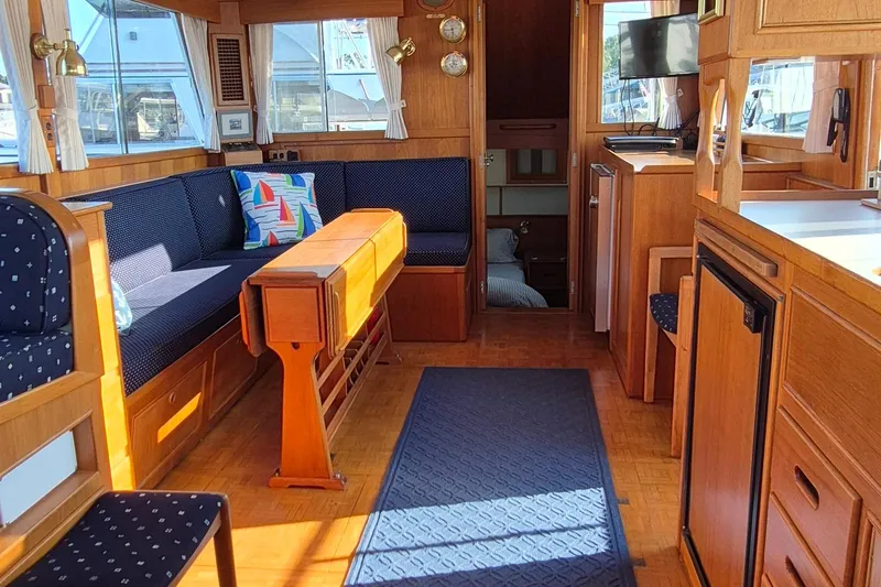 Slide: The Image of Interior of 1987 Grand Banks 42 Classic Trawler, featuring cozy seating and wooden cabinetry. - 3