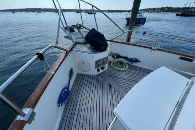Slide: The Image of 1987 Grand Banks 42 Classic Trawler deck with nautical equipment and scenic harbor view. - 32
