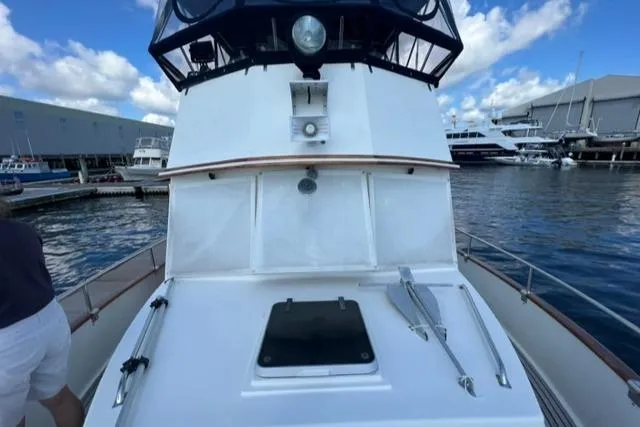 Slide: The Image of 1987 Grand Banks 42 Classic Trawler at marina, showcasing deck and cabin details. - 33
