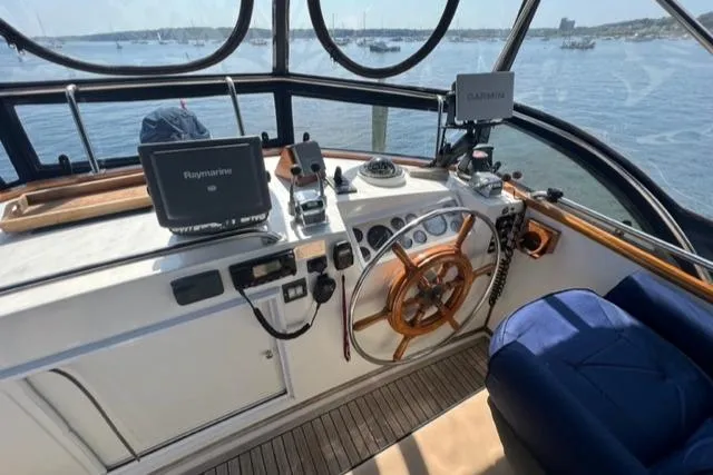 Slide: The Image of 1987 Grand Banks 42 Classic Trawler helm with navigation equipment, overlooking serene waters. - 38