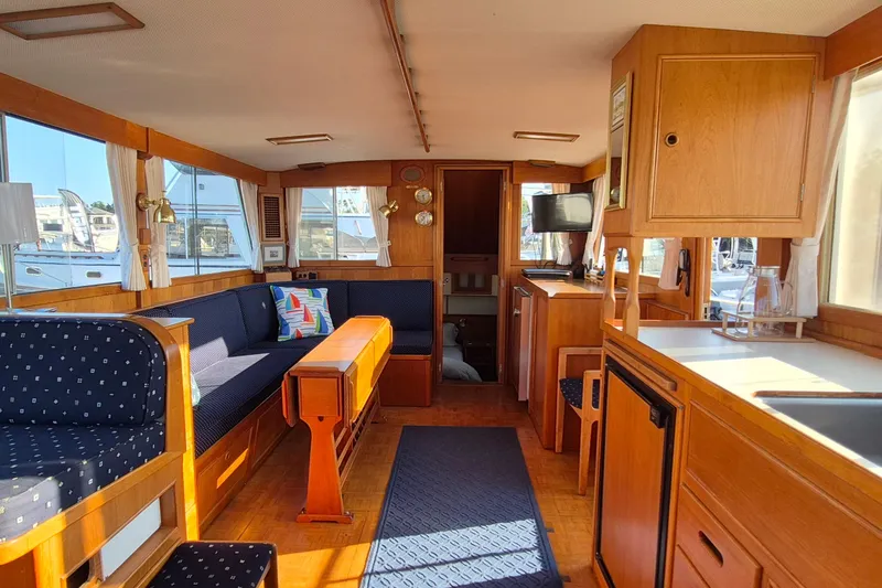 Slide: The Image of Interior of 1987 Grand Banks 42 Classic Trawler, featuring wood finishes and cozy seating. - 4