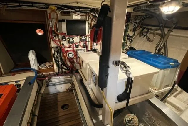 Slide: The Image of Engine room of 1987 Grand Banks 42 Classic Trawler, showcasing wiring and storage compartments. - 46